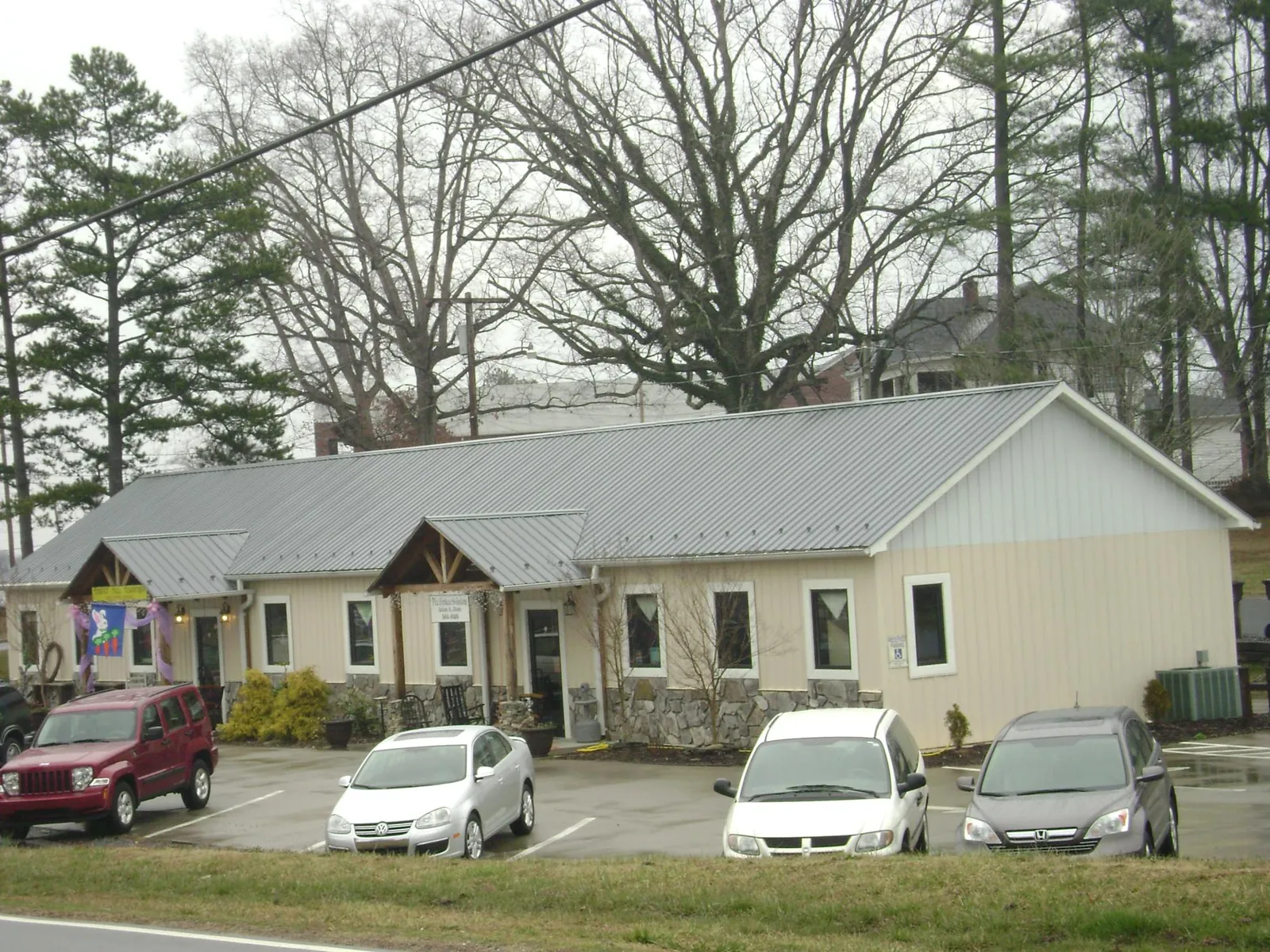 Gray metal roof with timber entry brackets on a small commercial building in Mcminnville